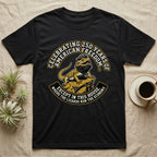 Bearded Dragon 1776 T-Shirt in Black — Bold woodcut tee of a bearded dragon in a tricorn hat black-bearding on a rock, gold and cream banner reading the lizards run the economy.