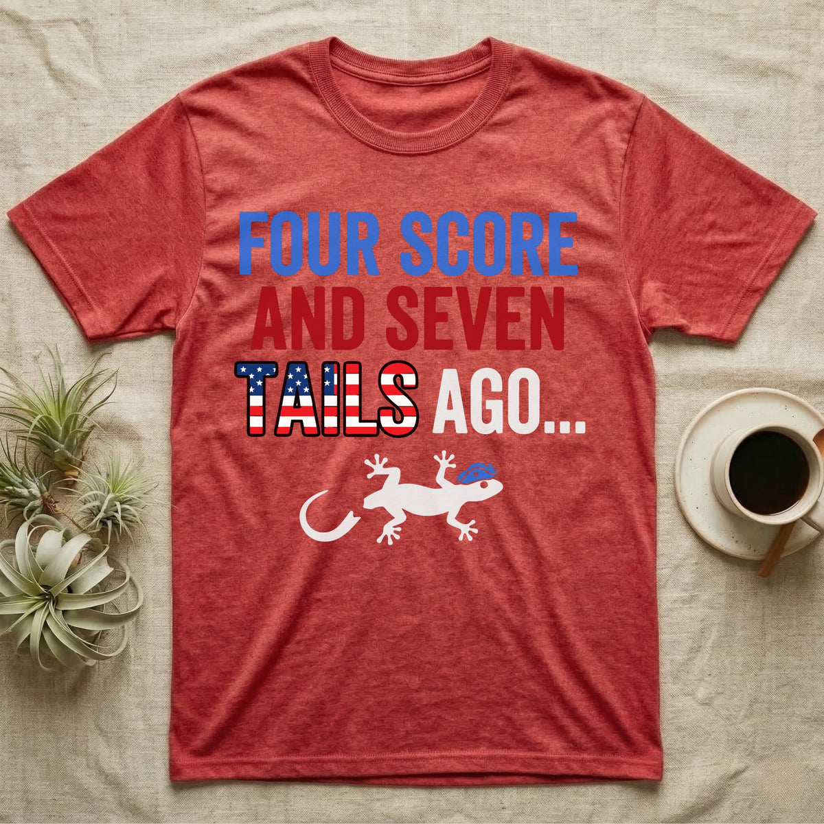 Gecko Four Score T-Shirt in Heather Red — Block text Four Score and Seven Tails Ago with a flag-filled word above a white gecko silhouette shedding its tail.
