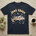 African Fat-Tailed Gecko Softie T-Shirt in Navy — African fat-tailed gecko with a plump tail under a puffy pastel "just thicc" bubble wordmark with tiny hearts.