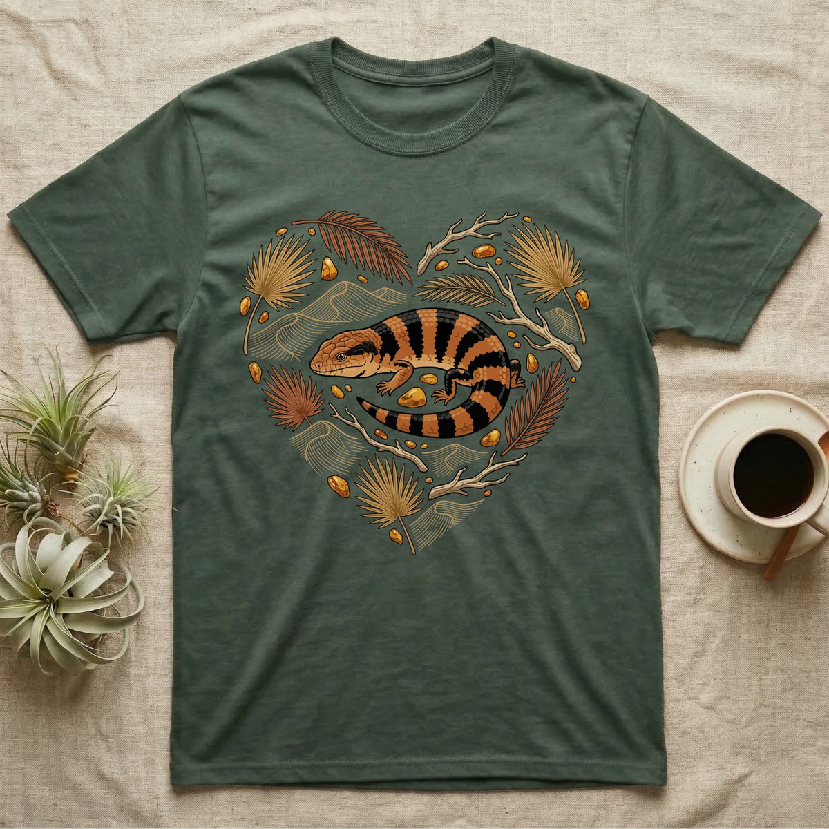 T-shirt with a heart-shaped illustration of a blue-tongued skink and tropical leaves.