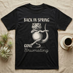 Bearded Dragon Brumating T-Shirt in Black — Bearded dragon in striped sunglasses doing a dance step, retro text reads Back In Spring, Gone Brumating