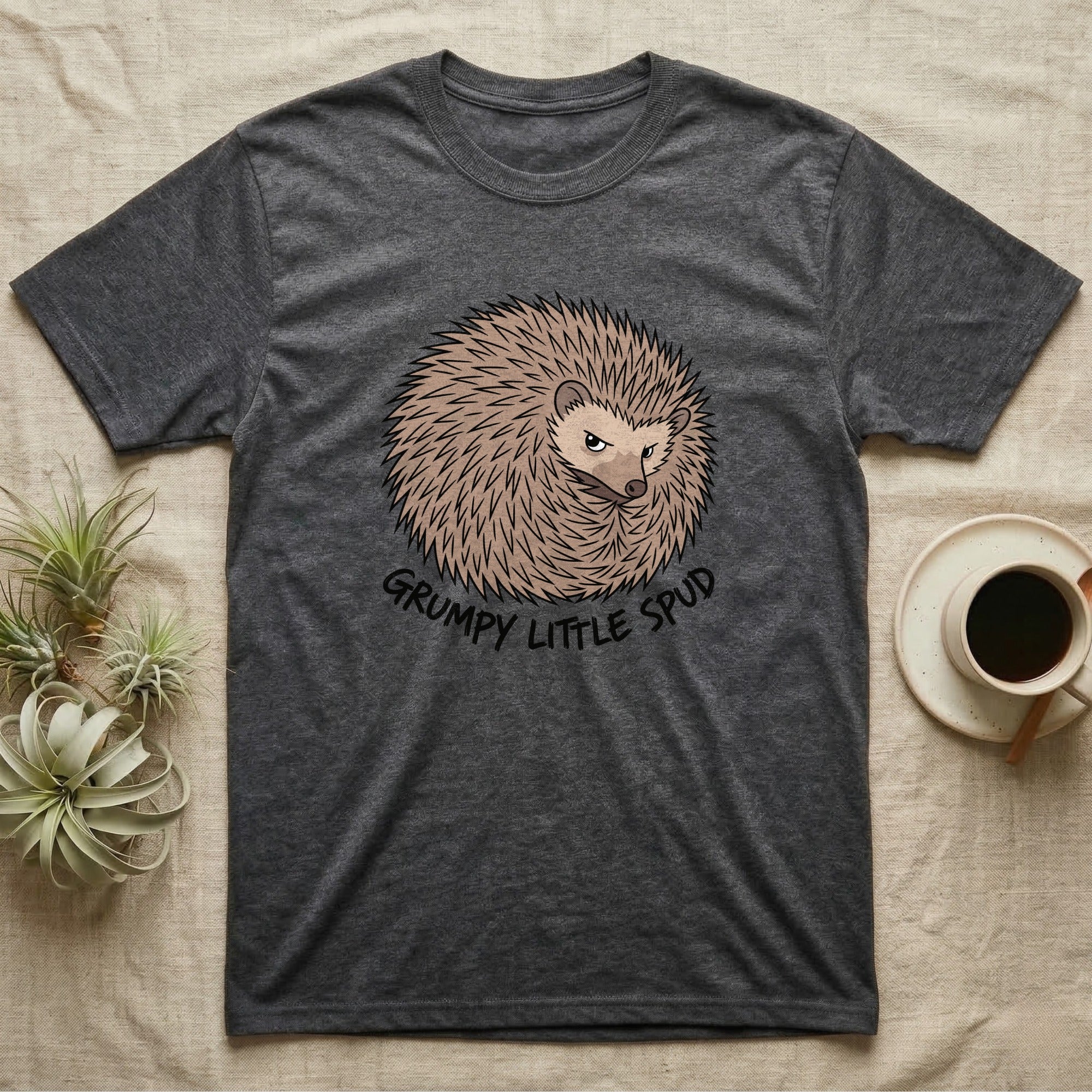 Dark gray t-shirt with a grumpy hedgehog graphic and text "GRUMPY LITTLE SPUD".