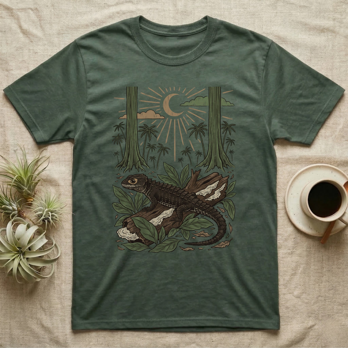 Crocodile Skink Home Range T-Shirt in Military Green — Woodcut-style illustration of a red-eyed crocodile skink crouched on a rainforest log among broad leaves and palms, no on-shirt text.