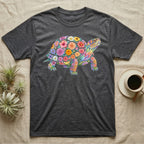 Box Turtle Mosaic T-Shirt in Dark Heather — An eastern box turtle on a rising diagonal, its domed shell and legs built from painted watercolour flowers and leaves.