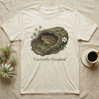Cream t-shirt with a toad in a mossy log, 'Currently Occupied' text.