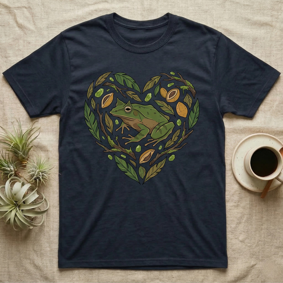 Dark t-shirt with a green frog and leaves forming a heart shape.