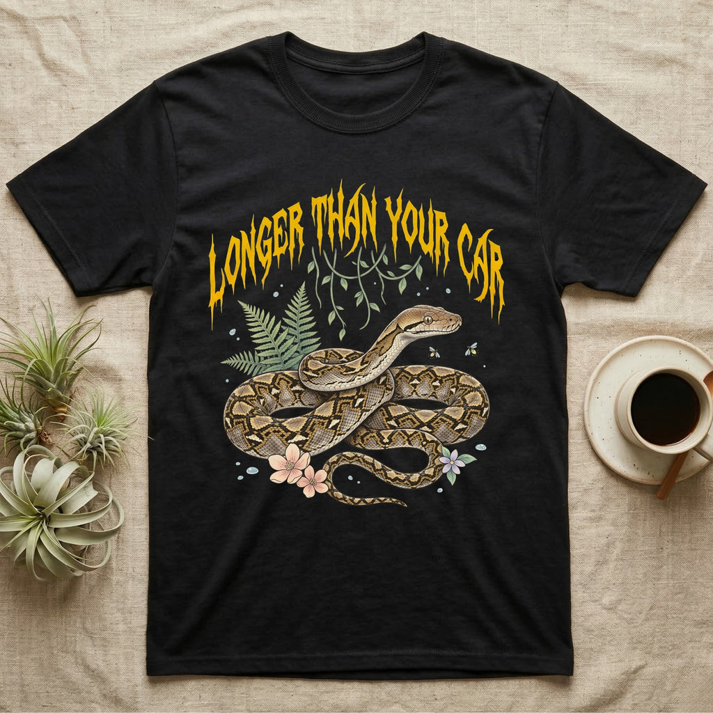 Reticulated Python Feral T-Shirt in Black — Reticulated python in net-patterned coils under jagged molten-gold metal text LONGER THAN YOUR CAR with pastel ferns