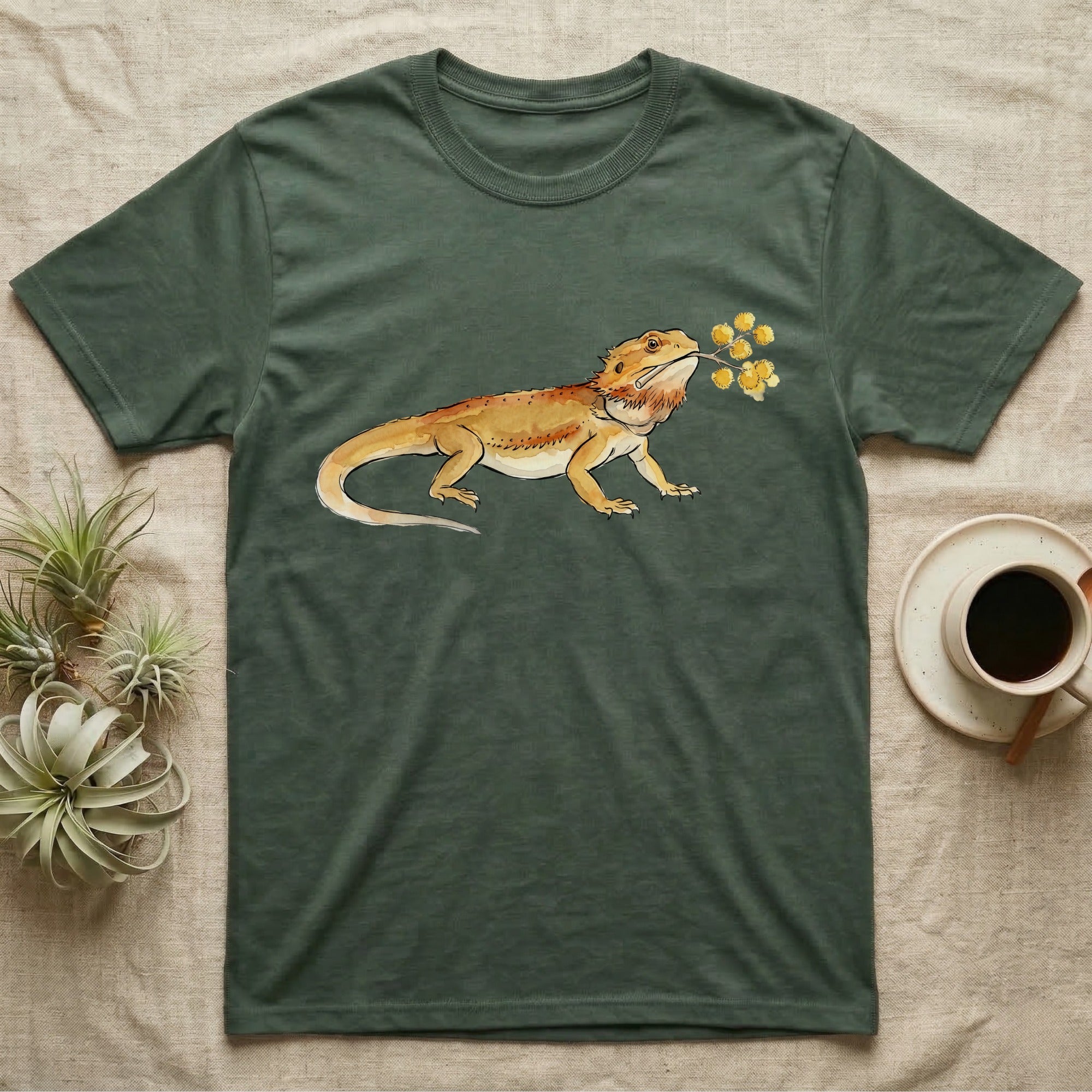 Bearded Dragon Blossom T-Shirt in Military Green — Watercolor illustration of an ochre bearded dragon holding a golden wattle blossom sprig, on a dark grey t-shirt.