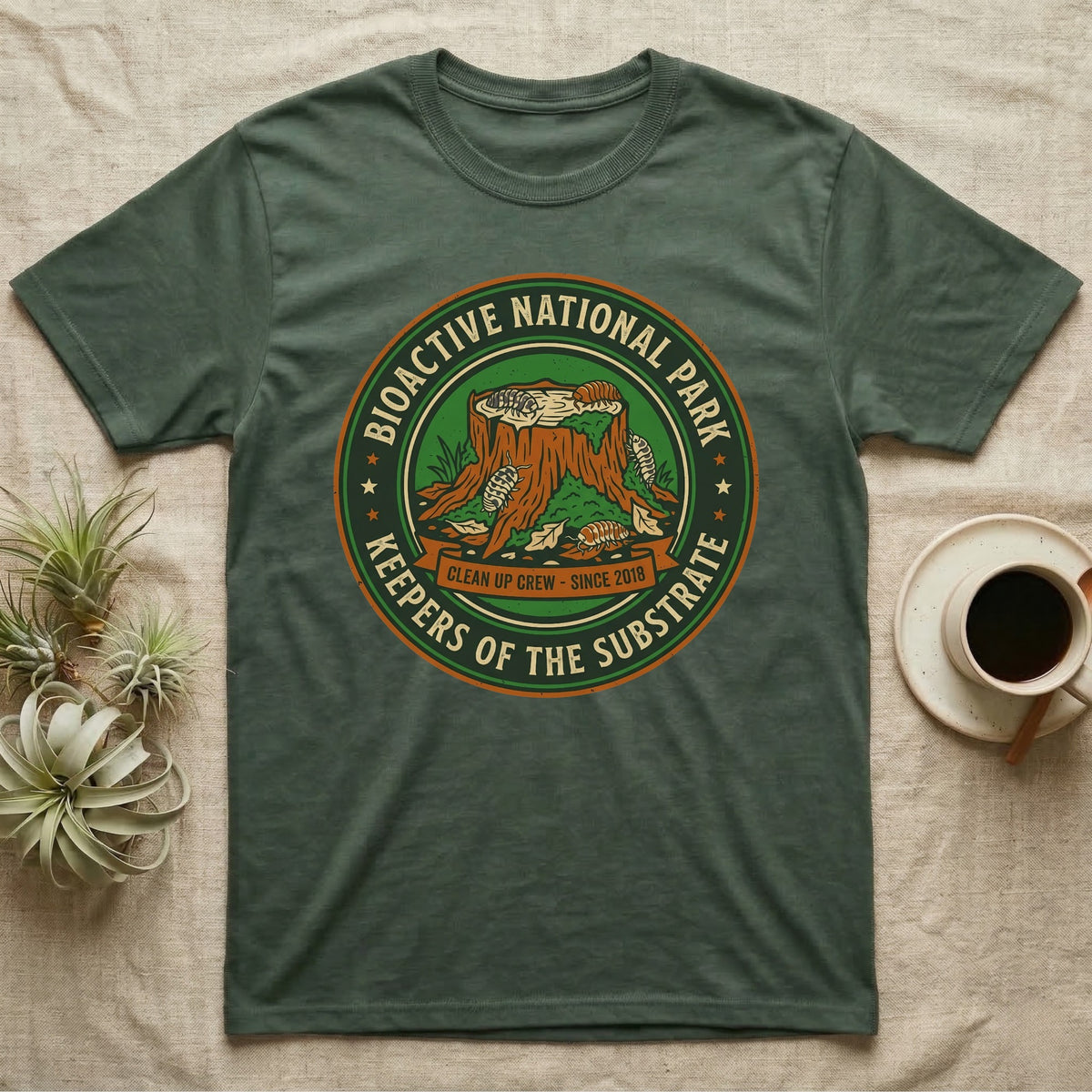 Isopod Keepers of the Substrate T-Shirt in Military Green — Weathered green park badge with isopods working a mossy stump and leaf litter, cream arc lettering.