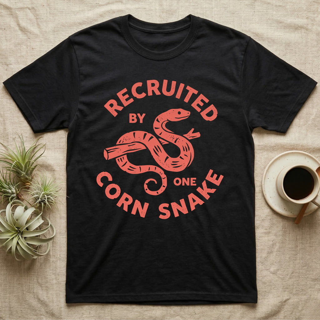 Corn Snake Recruit T-Shirt in Black — Hand-carved block-print badge of a corn snake on a branch inside ring lettering reading Recruited By One Corn Snake.