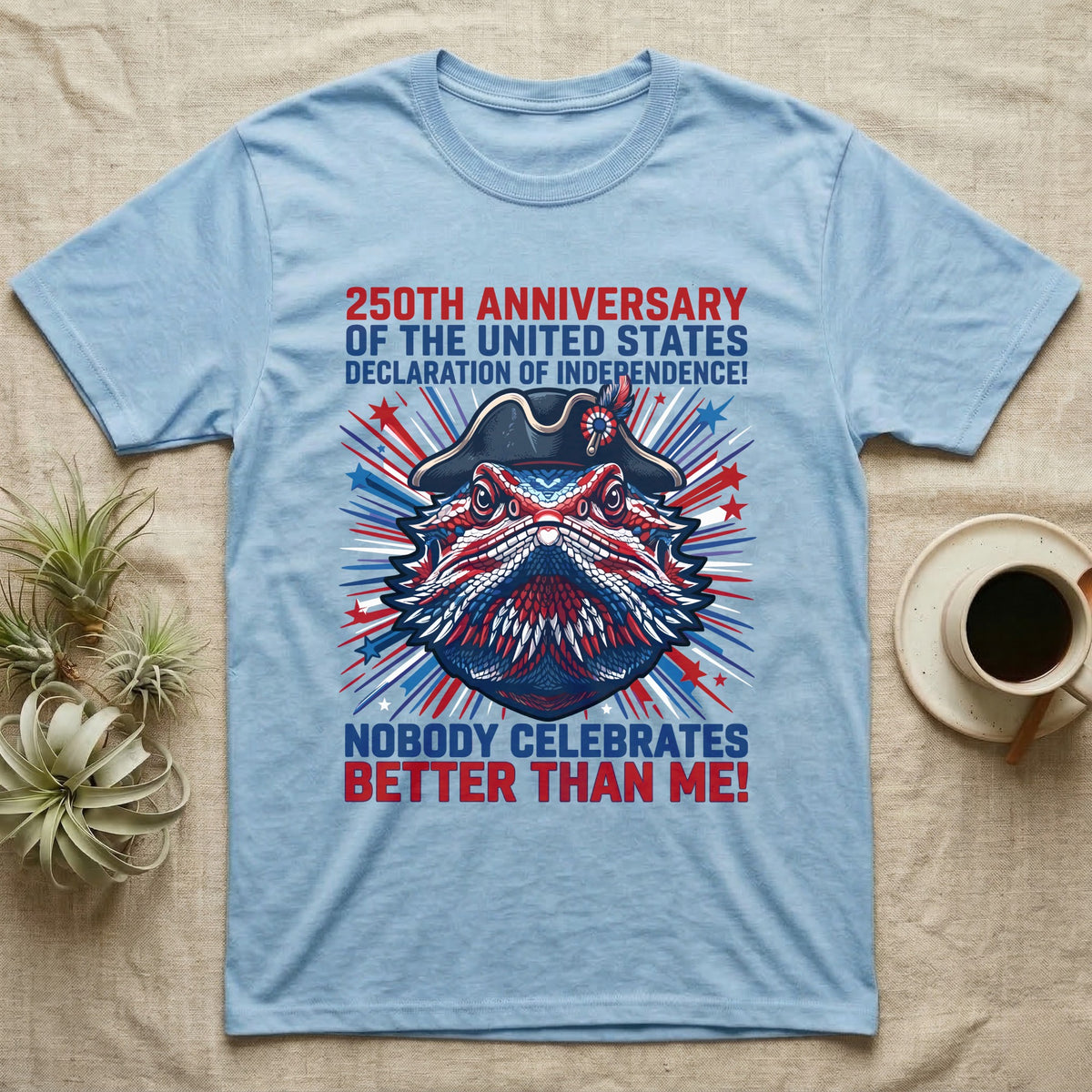 Bearded Dragon Fireworks T-Shirt in Light Blue — Pop-art bearded dragon head in a tricorn hat amid red-white-blue fireworks under Nobody Celebrates Better Than Me.