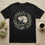 Black t-shirt with a sleeping possum in a floral wreath design.