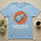 Blue Death Feigning Beetle T-Shirt in Light Blue — Distressed disc portrait of a blue death-feigning beetle over an orange circle with text plays dead