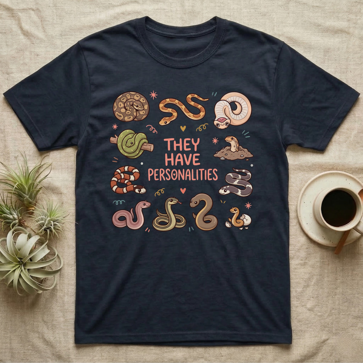 Snake Keeper Personalities T-Shirt in Navy — Outline illustration of five snakes in different postures scattered around hand-lettered script on grey.