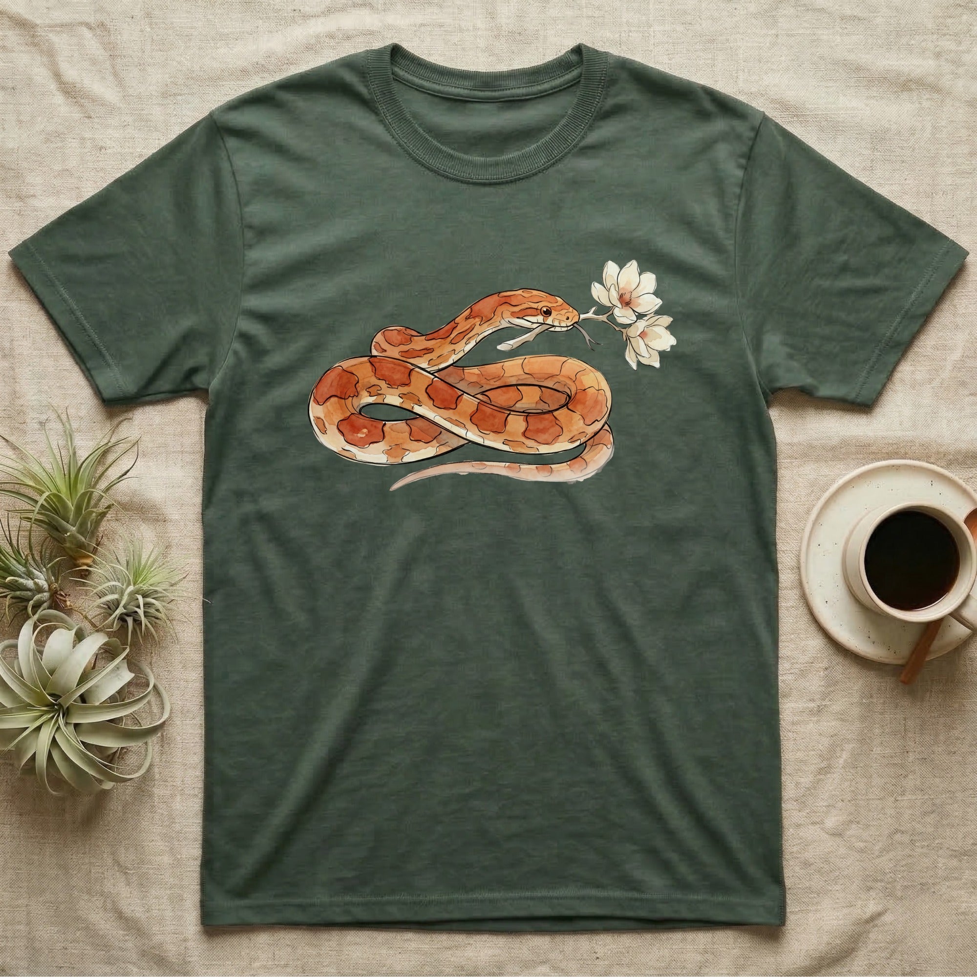 Corn Snake Blossom T-Shirt in Military Green — Watercolor illustration of an orange-and-cream corn snake holding a magnolia blossom sprig, on a dark grey t-shirt.