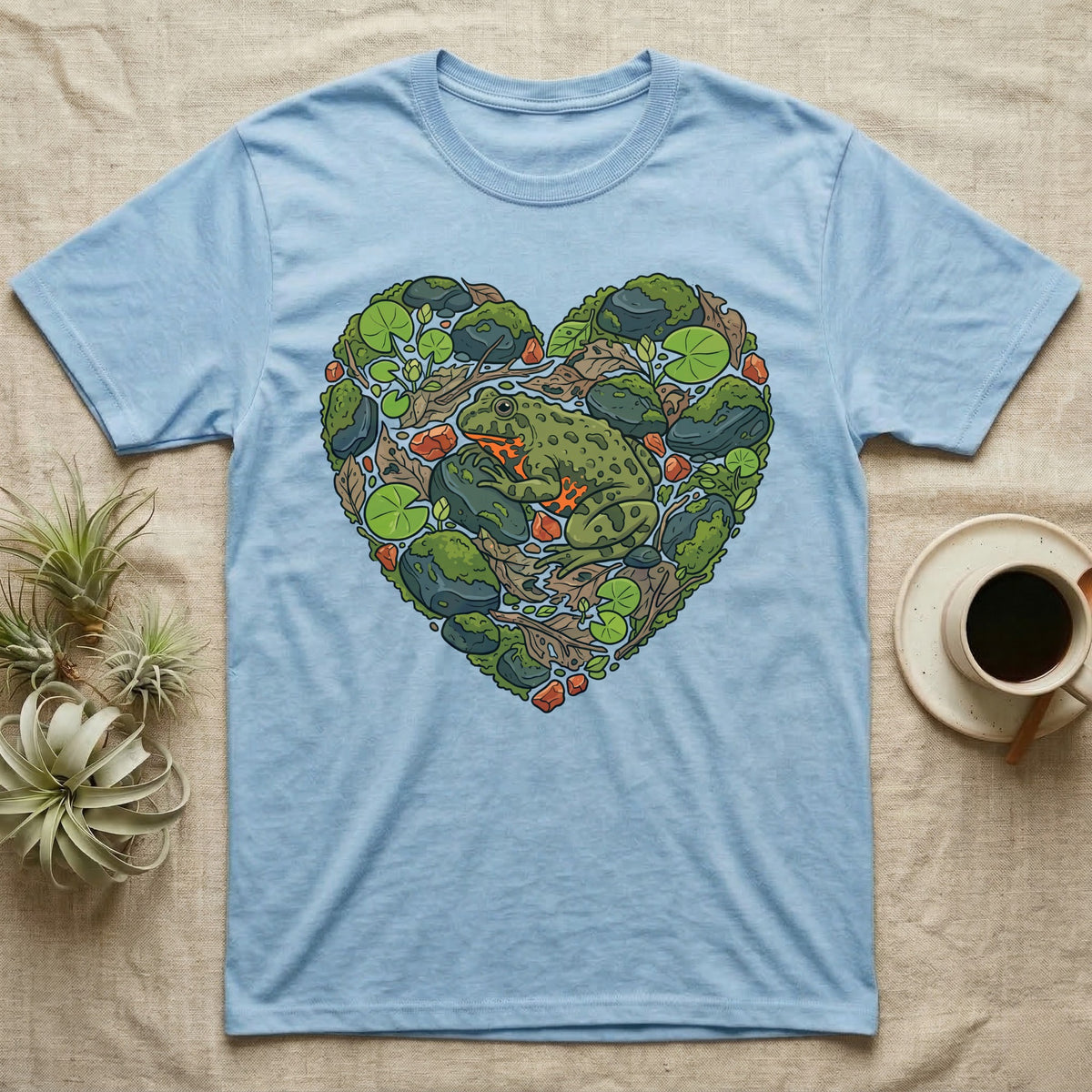 Light blue t-shirt with a heart-shaped nature scene featuring a frog.