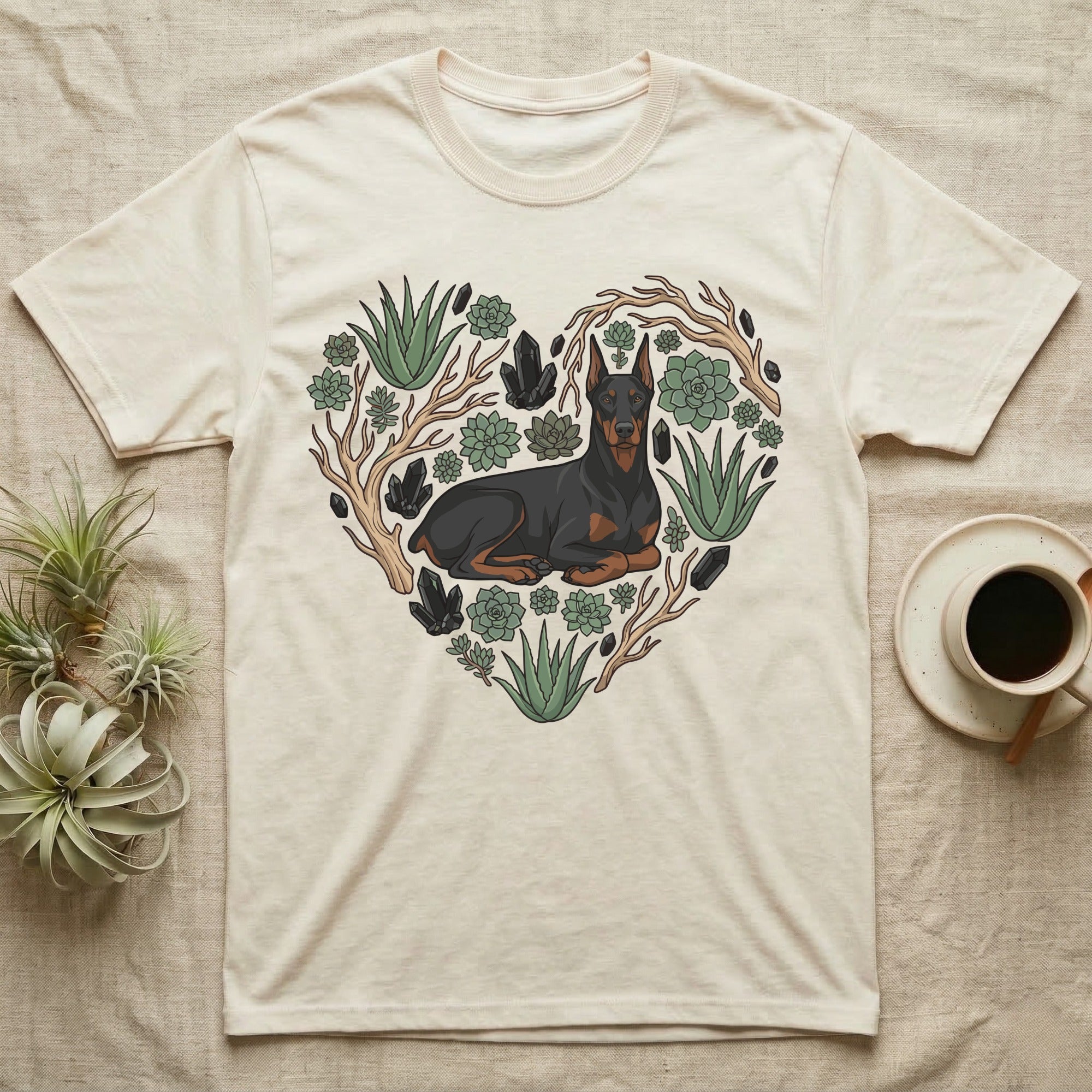 Doberman pinscher within a heart-shaped succulent and crystal arrangement on a cream t-shirt.
