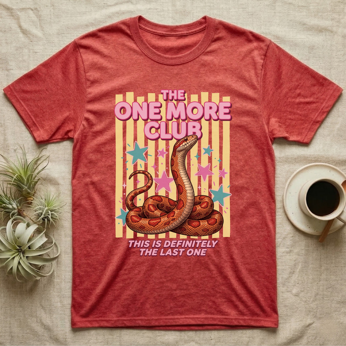 Corn Snake Club T-Shirt in Heather Red — Engraved corn snake sitting deadpan under pink lettering The One More Club, with This is definitely the last one below, on yellow stripes