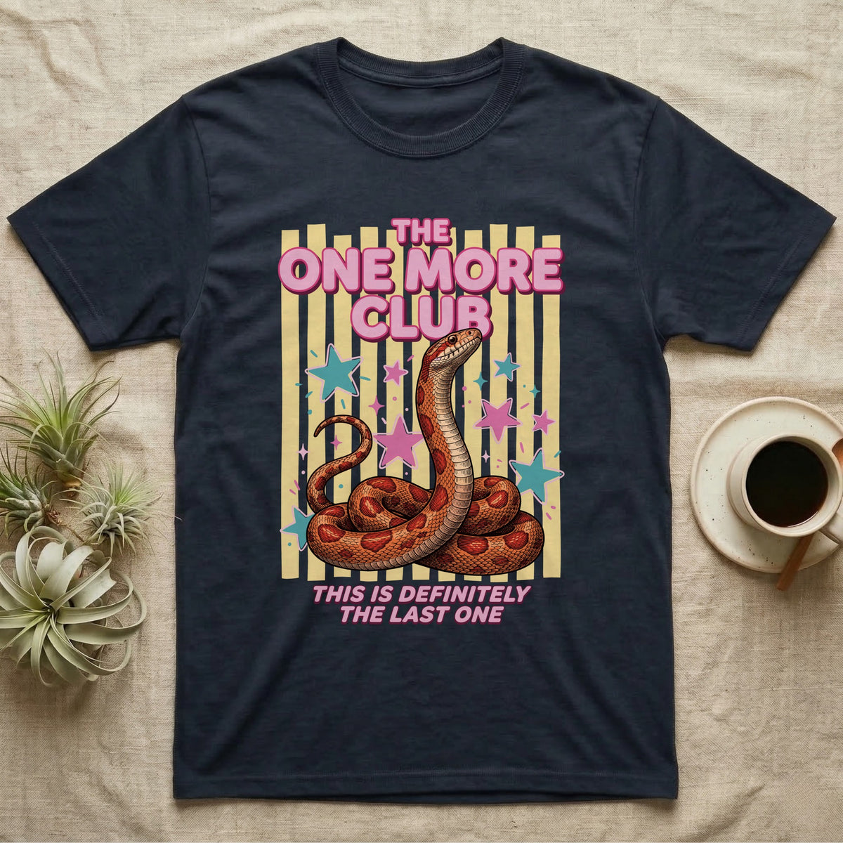 Corn Snake Club T-Shirt in Navy — Engraved corn snake sitting deadpan under pink lettering The One More Club, with This is definitely the last one below, on yellow stripes