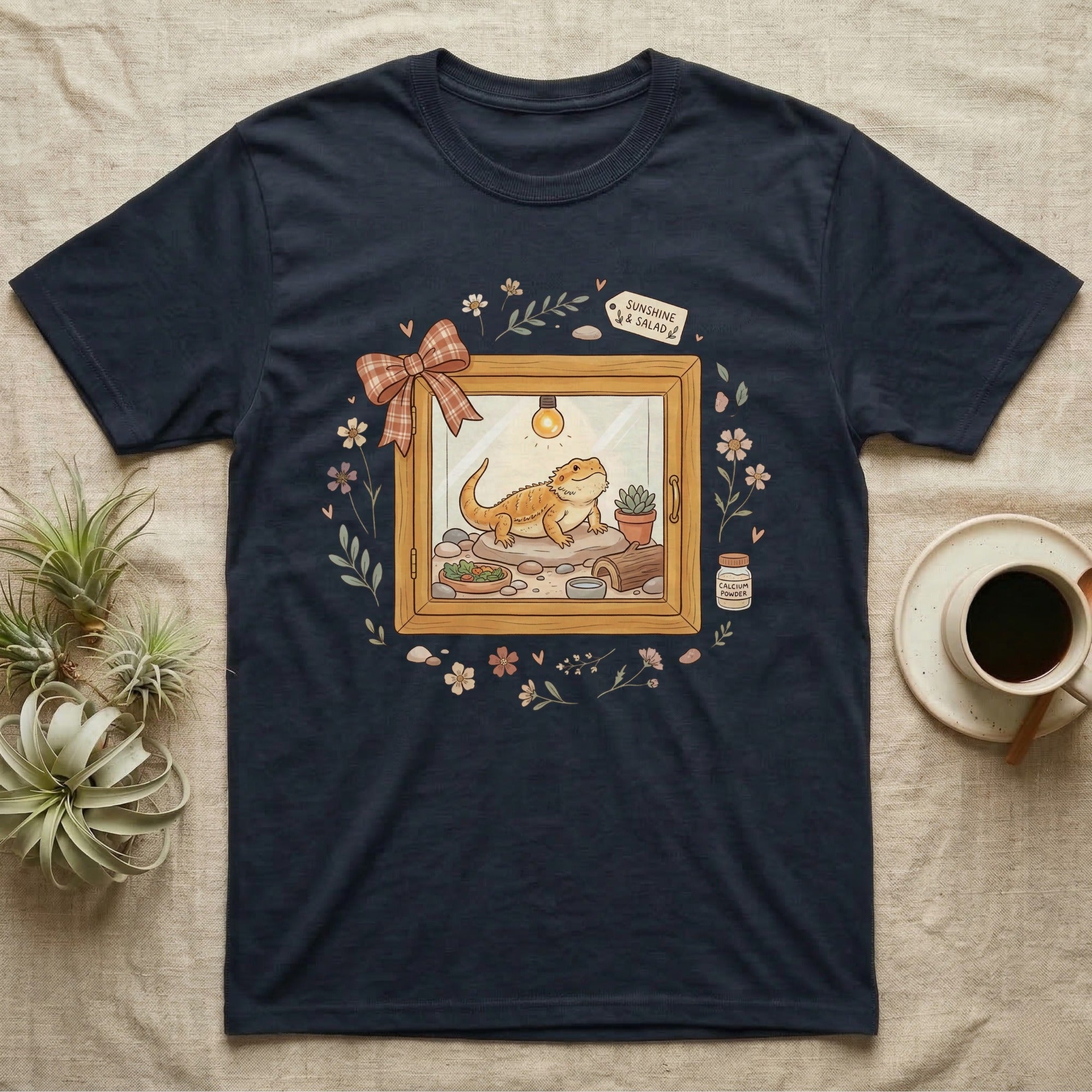Navy t-shirt with a cartoon bearded dragon in a terrarium setting.