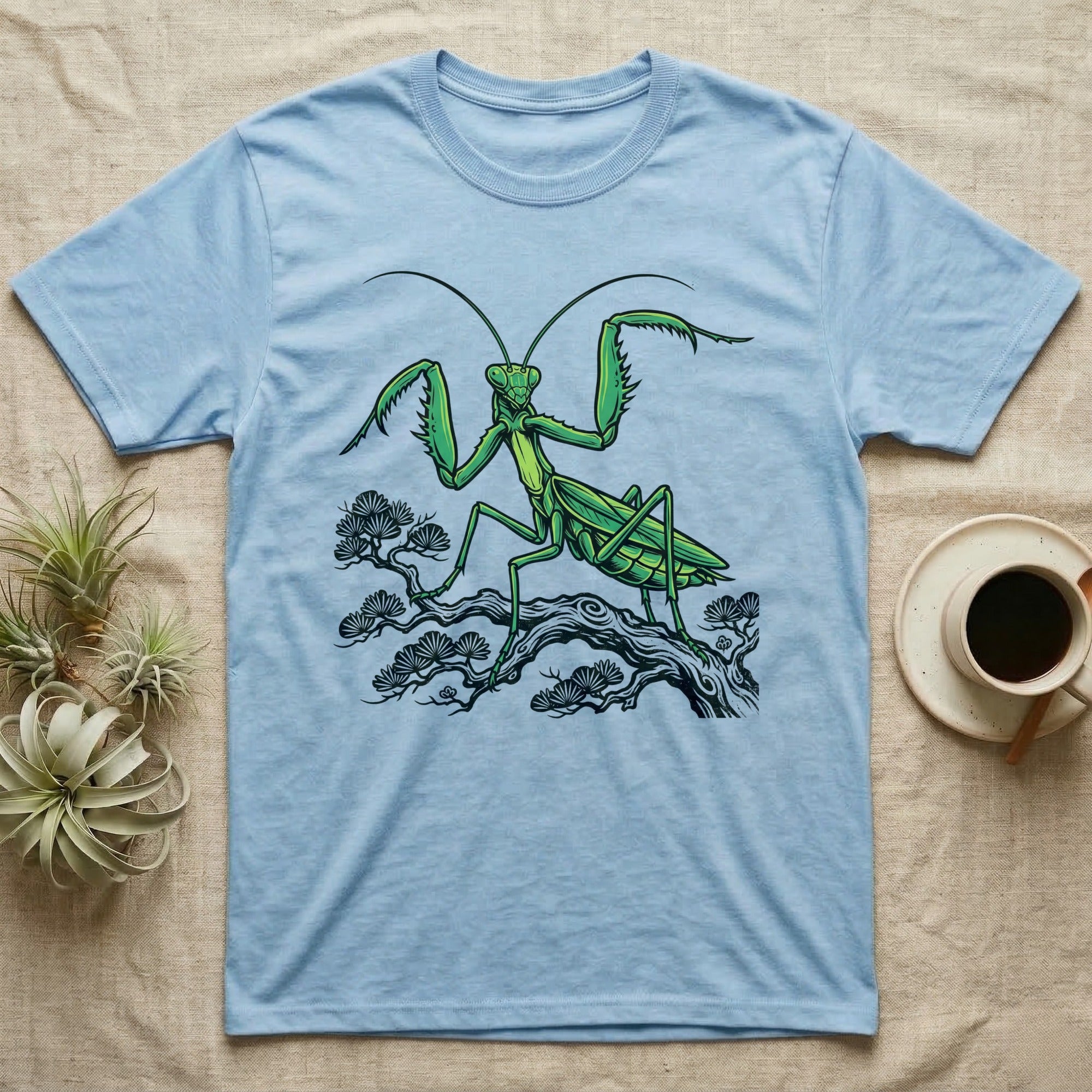 Light blue t-shirt with a green praying mantis on a tree branch.