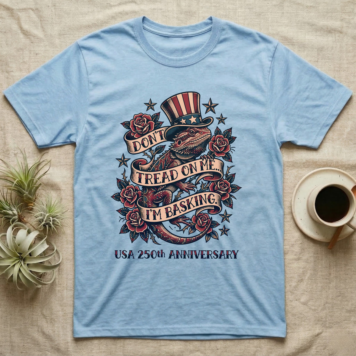 Bearded Dragon Tattoo T-Shirt in Light Blue — Tattoo-flash bearded dragon in a star top hat among roses with banners reading Don't Tread On Me I'm Basking.
