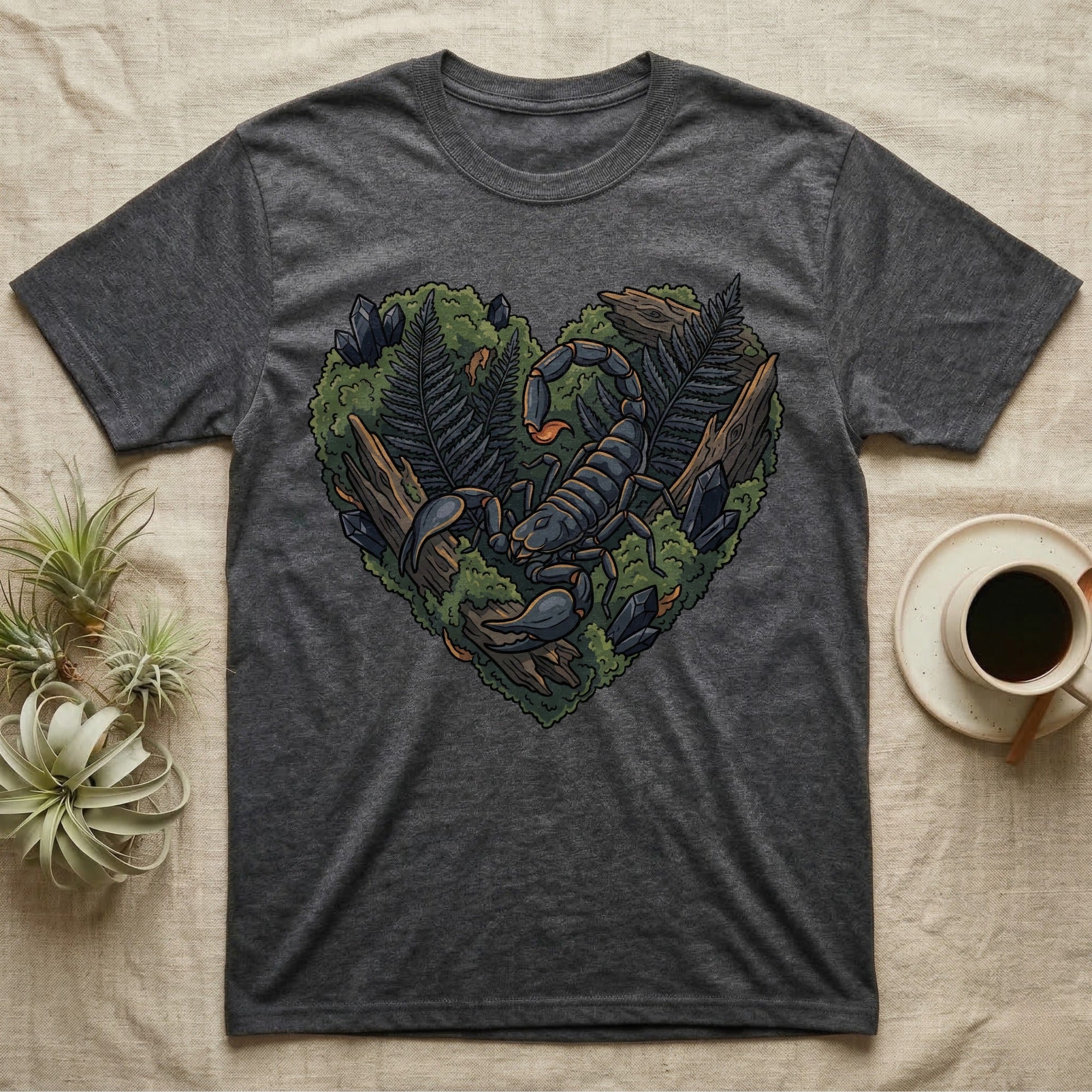 Dark grey t-shirt with a heart-shaped design of a scorpion, rocks, and ferns.