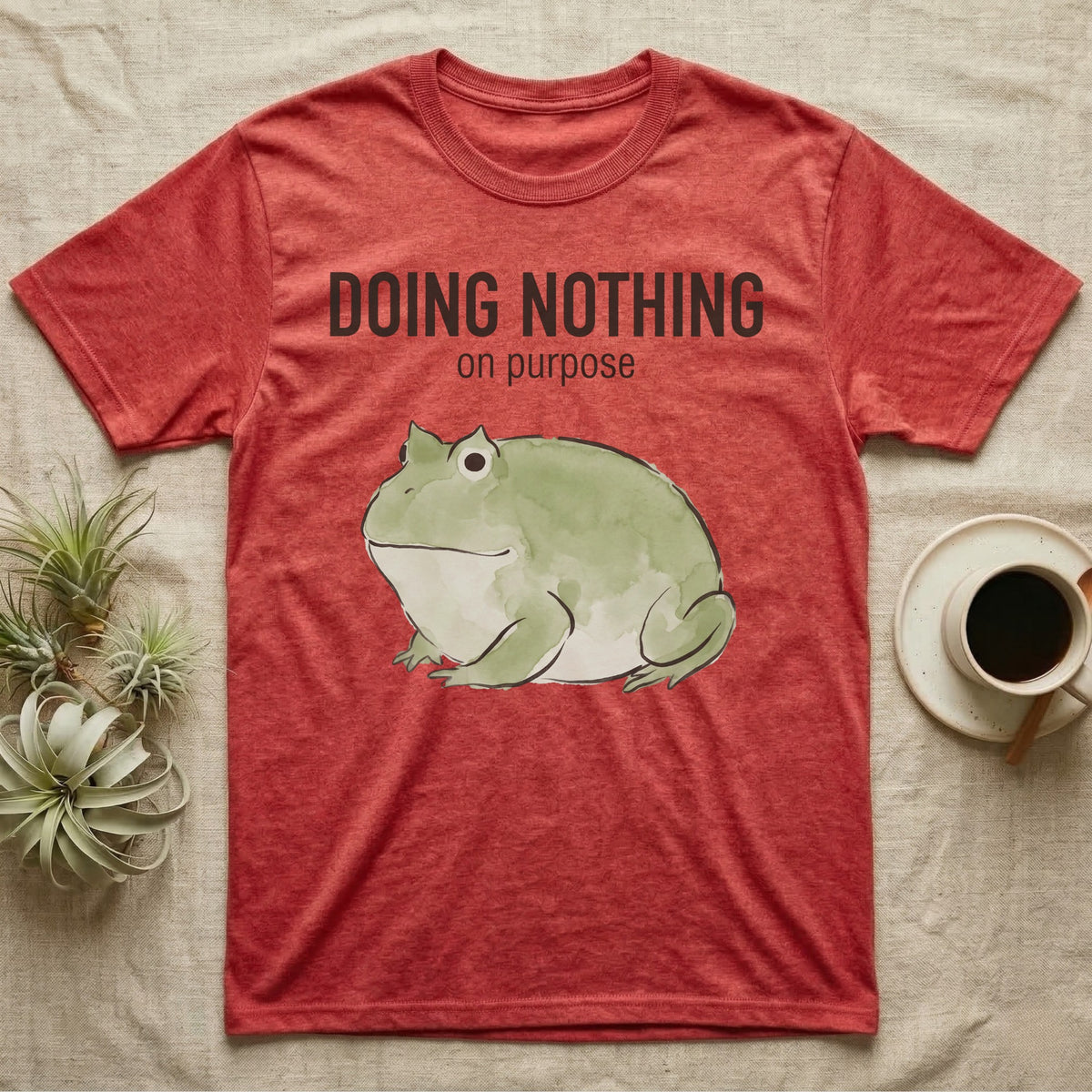 Pacman Frog Doing Nothing T-Shirt in Heather Red — Watercolour pacman frog blob in profile below the words doing nothing on purpose, on grey