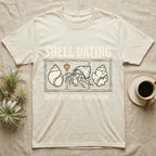 Hermit Crab Shell Dating T-Shirt in Natural — Vintage-ink hermit crab leaning toward a pristine shell, chipped shell on the right, carved type "Shell Dating. Swipe Left."