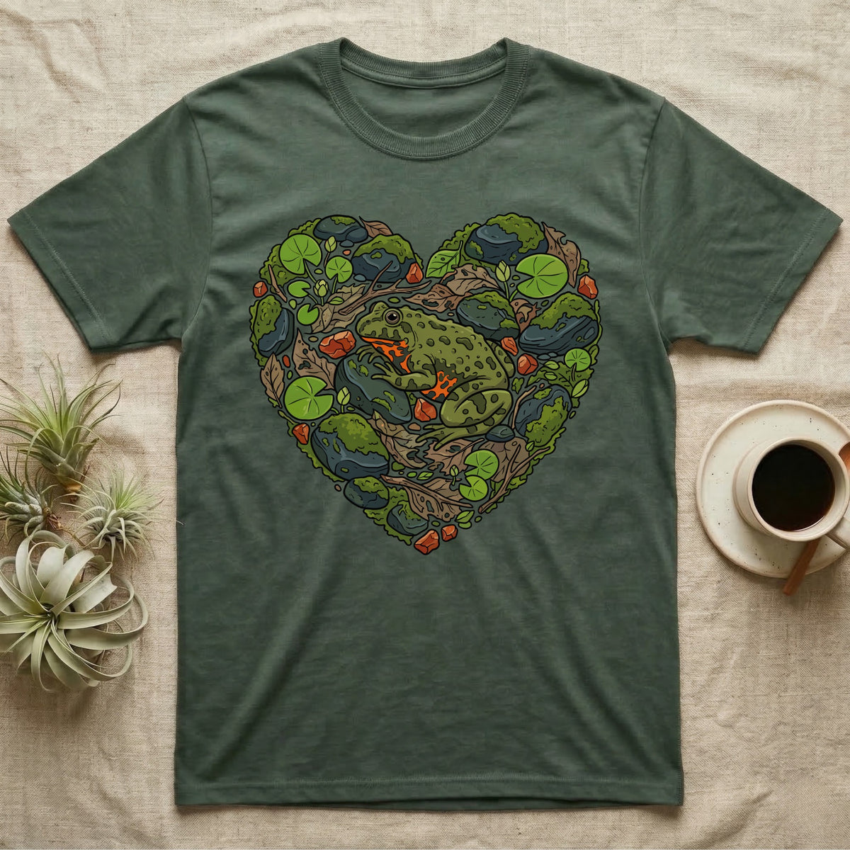 Green t-shirt with a frog and natural elements forming a heart.