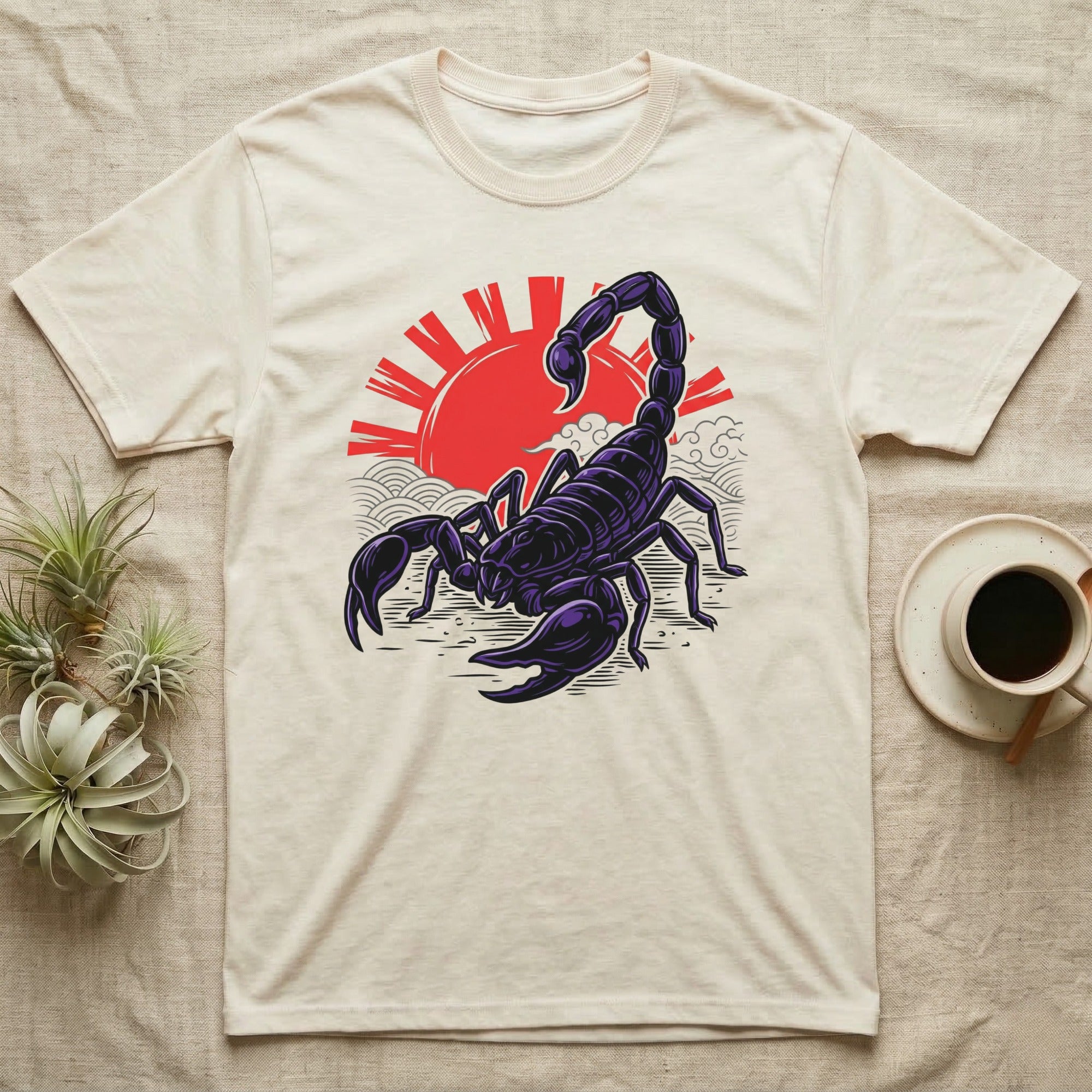 Cream t-shirt with a stylized black scorpion against a red sun and waves.