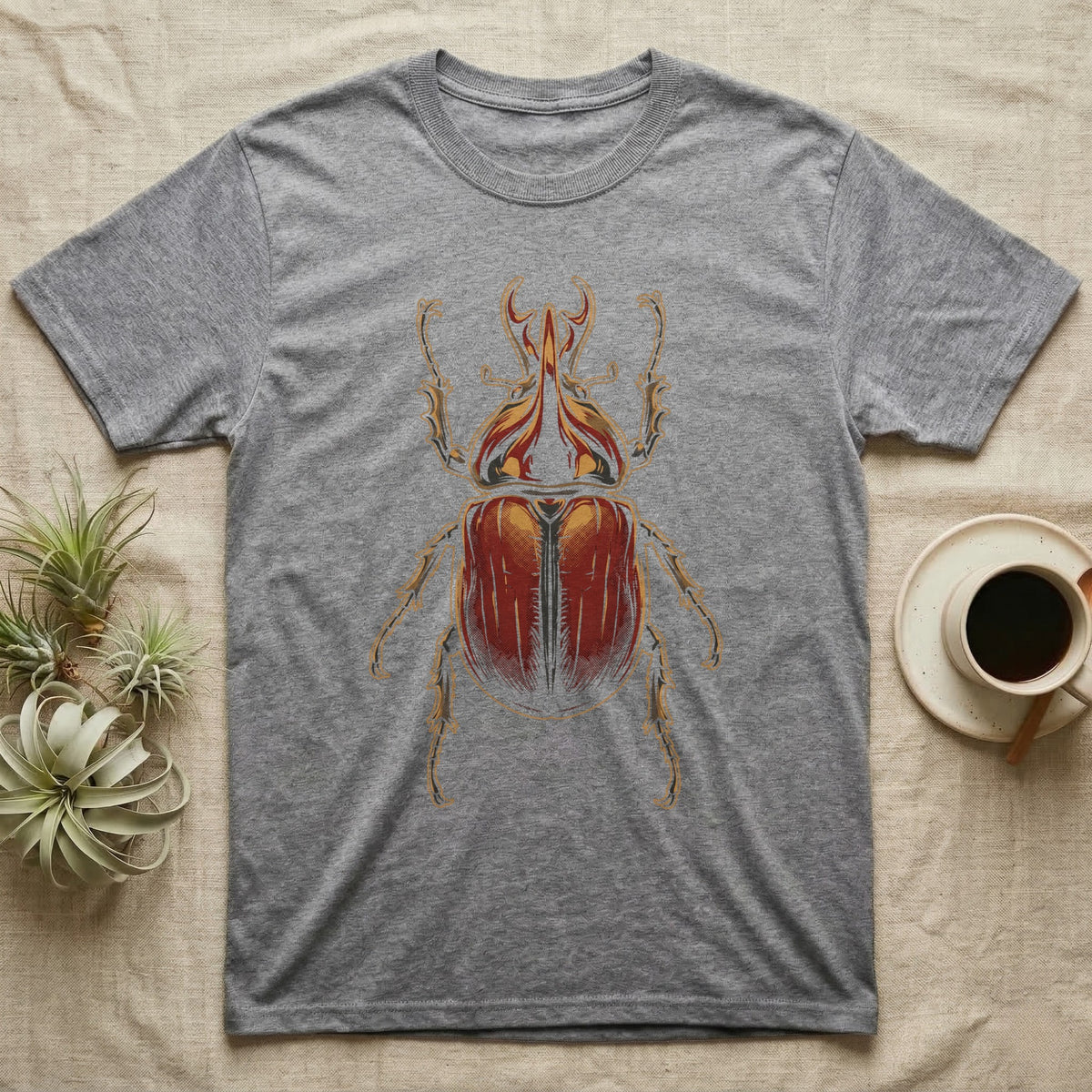 Dorsal-view illustration of a rhinoceros beetle with a forked amber horn and rust-red elytra in bold vintage comic ink line and halftone shading, no on-shirt text. — shown on a Sport Grey tee.
