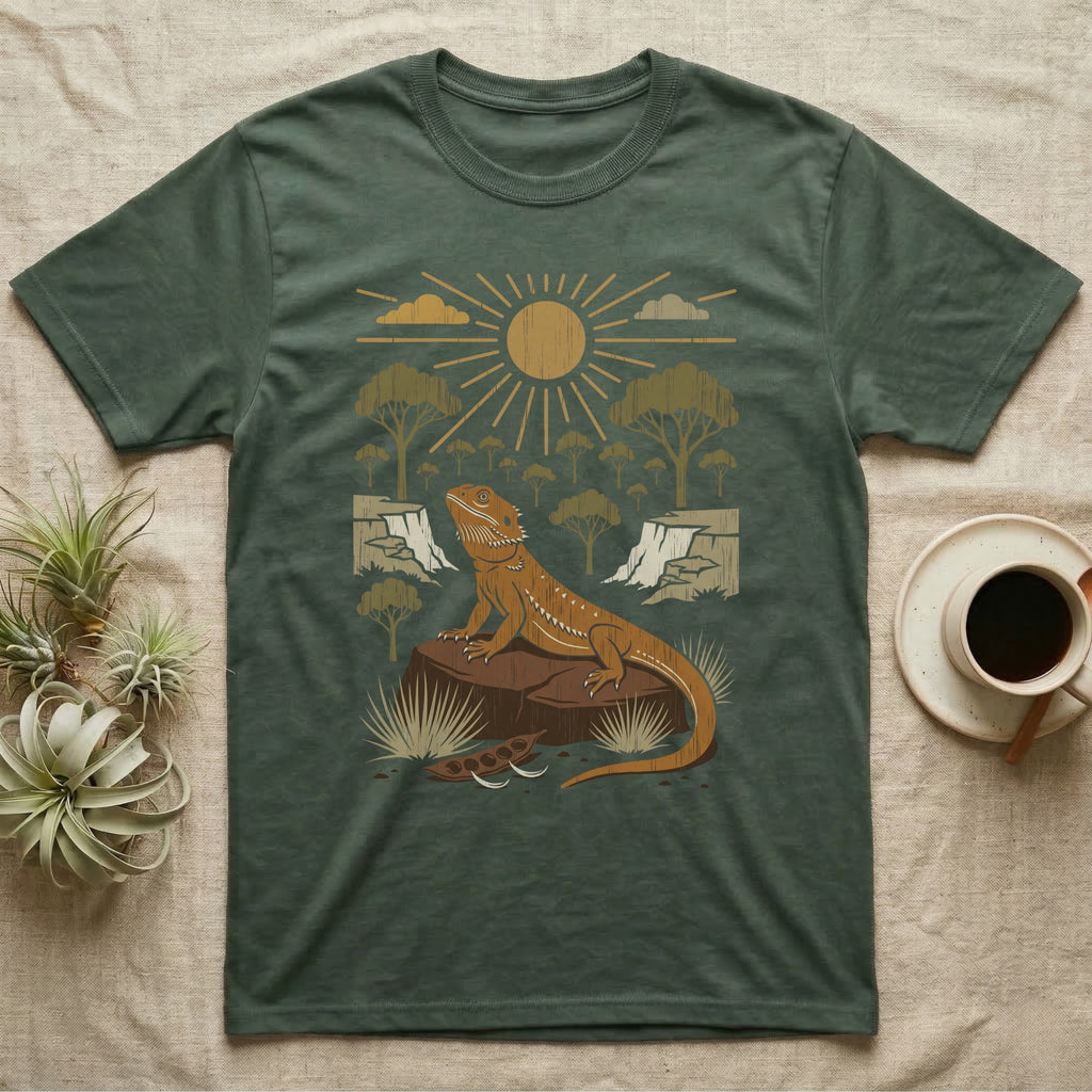 Bearded Dragon Home Range T-Shirt in Military Green — Woodcut-style illustration of a bearded dragon basking on a boulder under a full sun with arid scrub trees and escarpments behind, no on-shirt text.