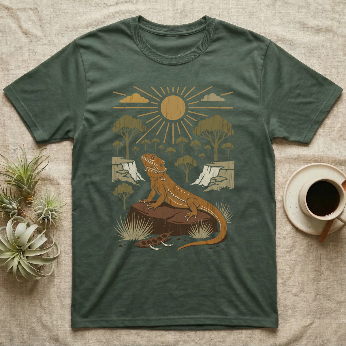 Bearded Dragon Home Range T-Shirt in Military Green — Woodcut-style illustration of a bearded dragon basking on a boulder under a full sun with arid scrub trees and escarpments behind, no on-shirt text.