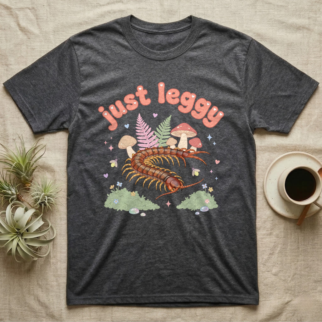 Vietnamese Centipede Baby T-Shirt in Dark Heather — Many-legged Vietnamese centipede curving among pastel ferns and toadstools under puffy coral text "just leggy".