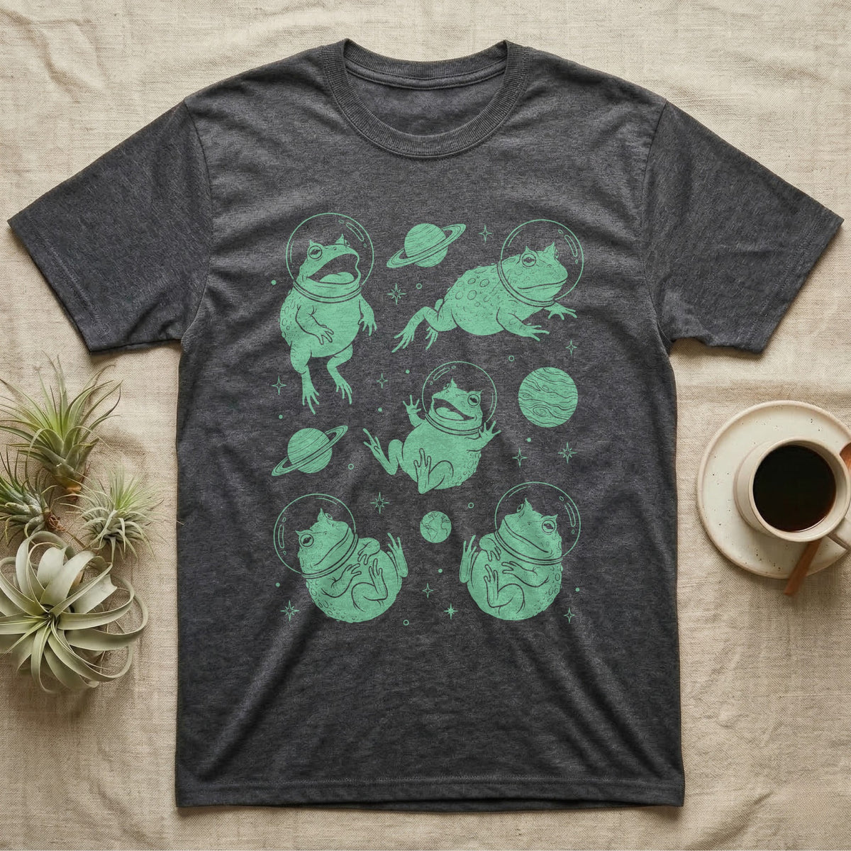 Pacman Frog Cosmic T-Shirt in Dark Heather — Vintage screen-print illustration of Pacman frogs in astronaut helmets floating in space, cosmic jade green monochromatic on dark background.