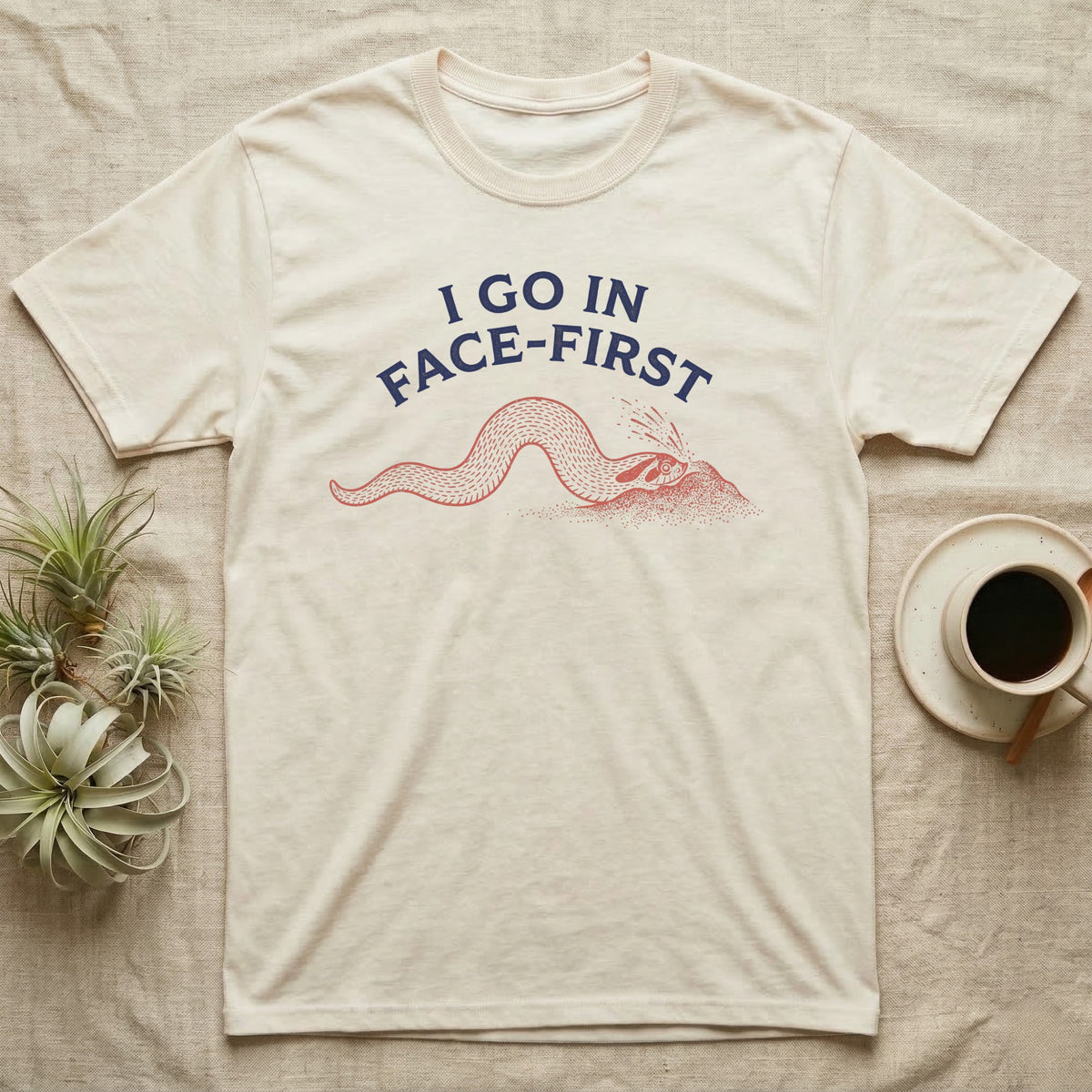 Western Hognose Face-First T-Shirt in Natural — Two-ink worn-stamp print of a western hognose snake digging head-first into a mound of sand beneath arched text reading I GO IN FACE-FIRST.