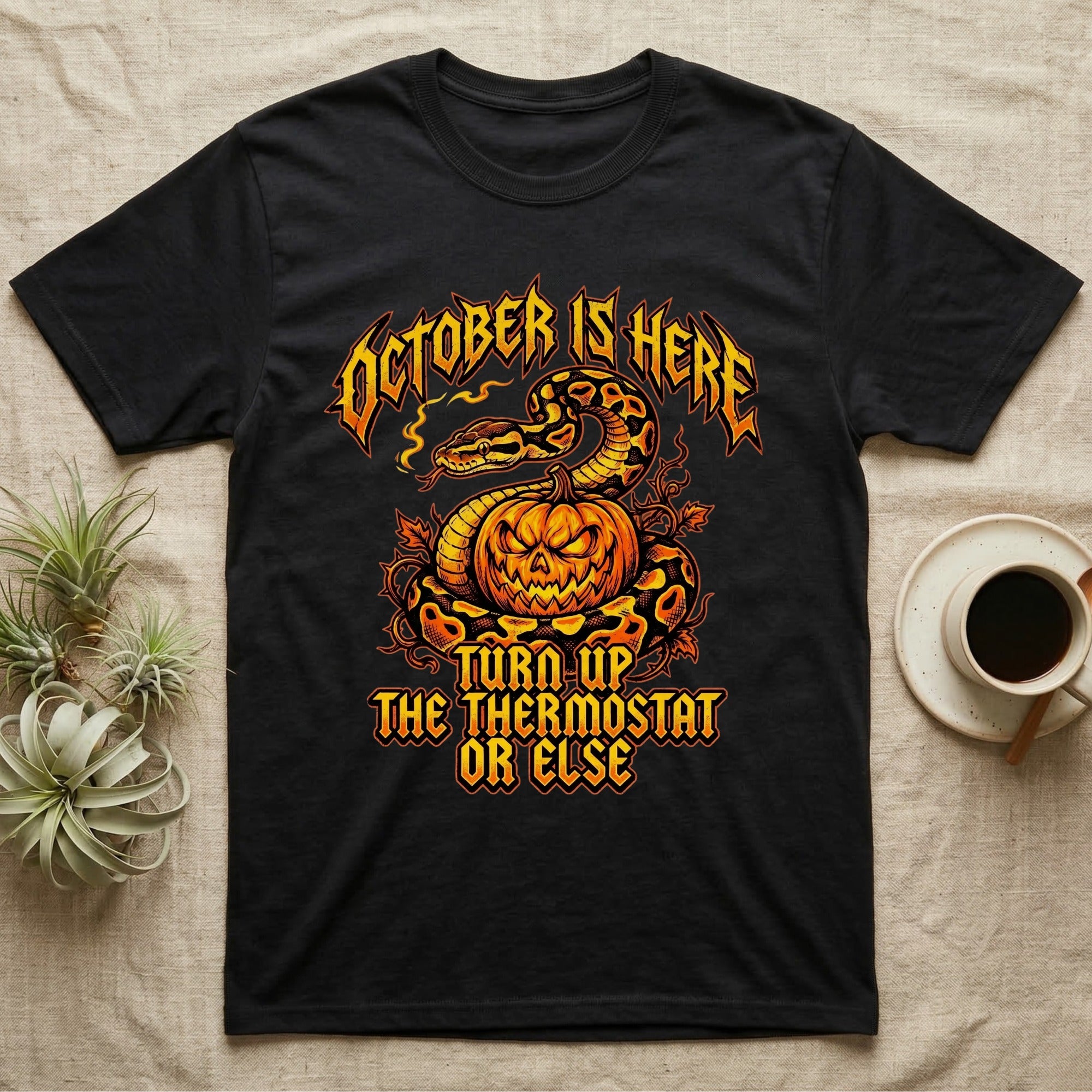 Ball Python October Thermostat T-Shirt in Black — Metal-band style ball python coiled over a glowing jack-o'-lantern, "October Is Here, Turn Up the Thermostat Or Else."