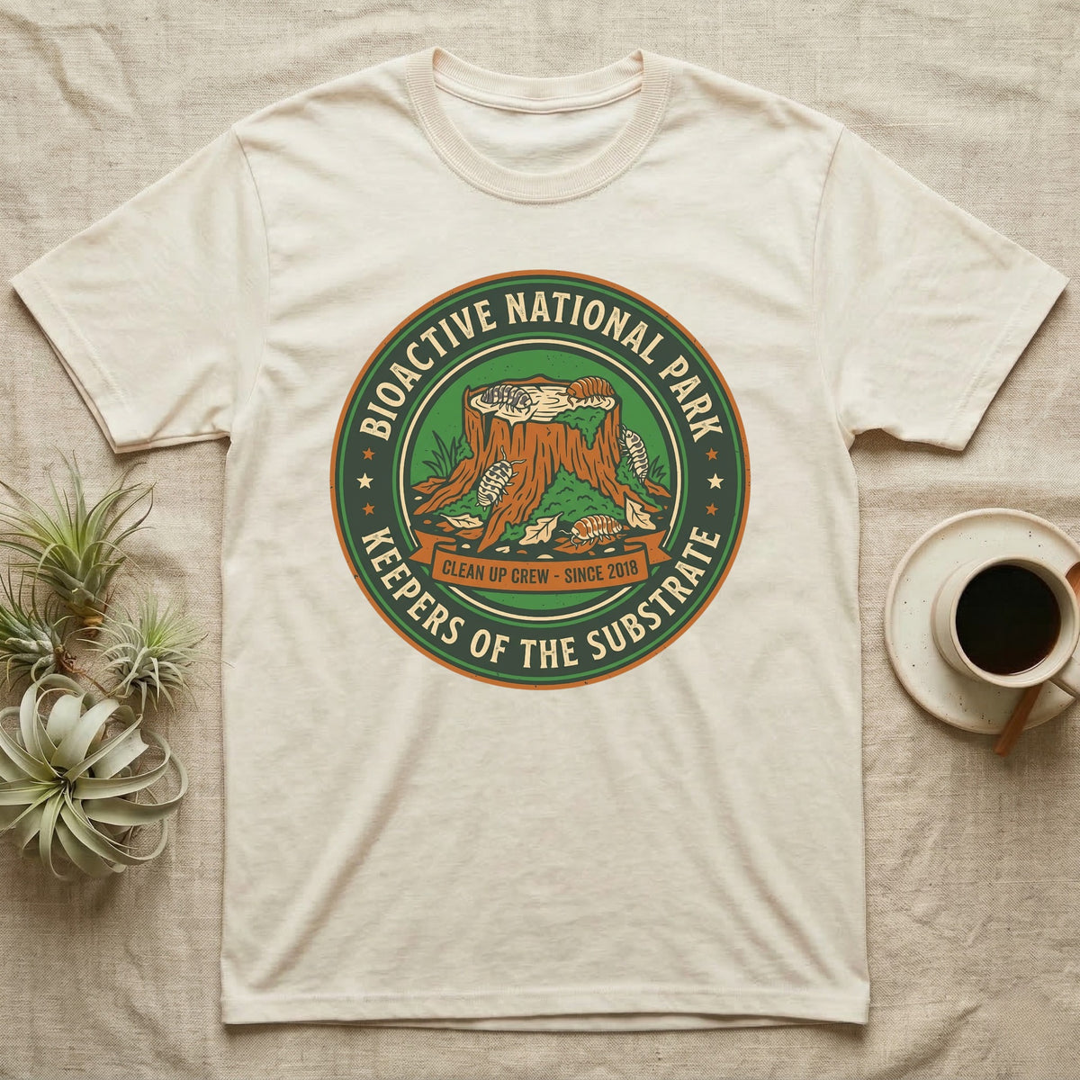 Isopod Keepers of the Substrate T-Shirt in Natural — Weathered green park badge with isopods working a mossy stump and leaf litter, cream arc lettering.