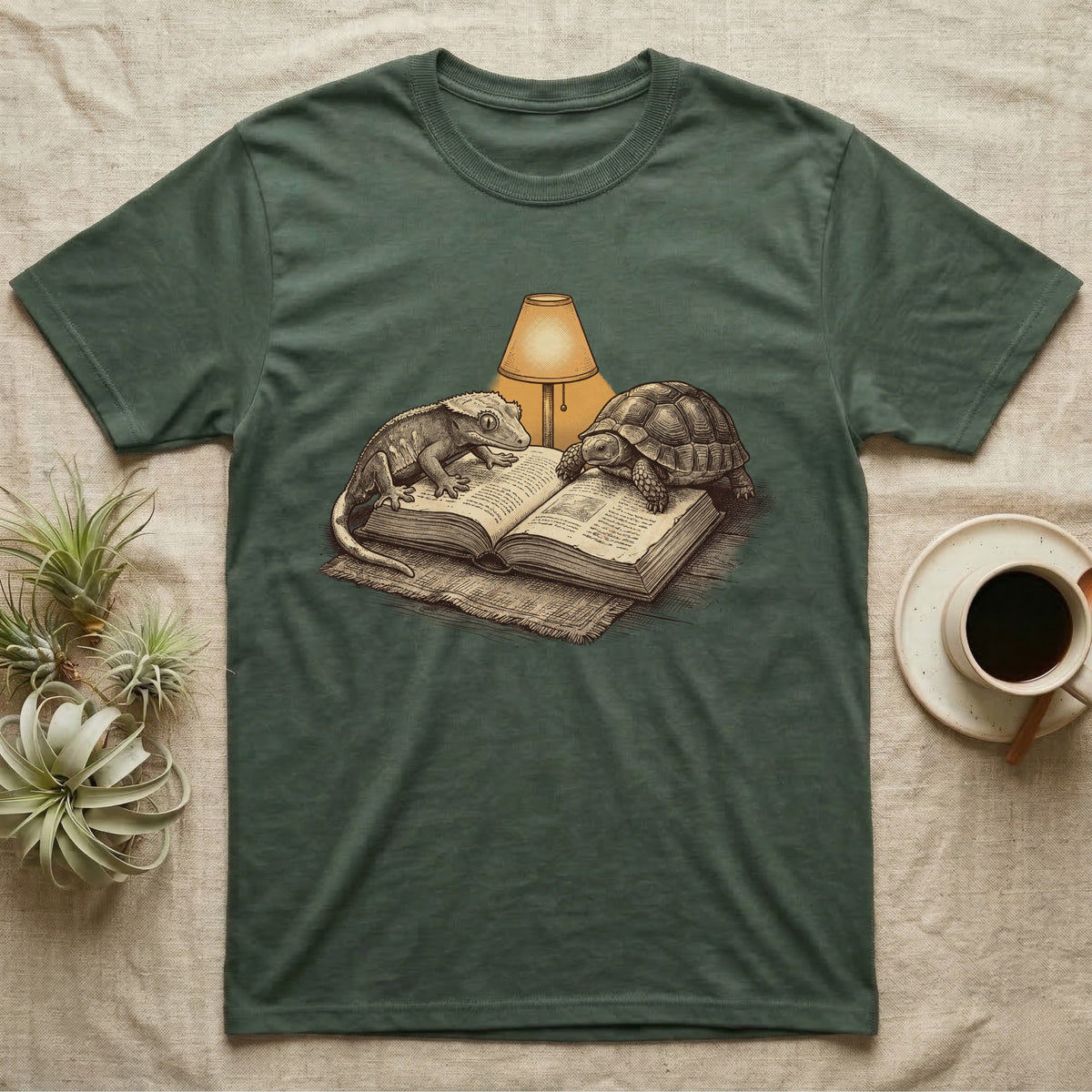 Cold-Blooded Book Club T-Shirt in Military Green — Engraved cozy illustration of a gecko and a tortoise sharing an open book under a glowing reading lamp.