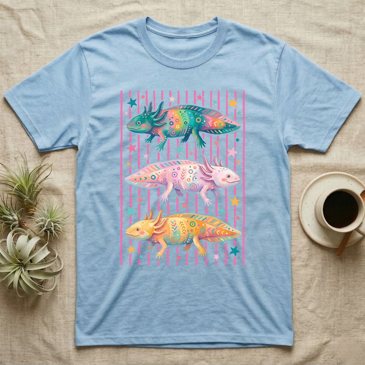 Axolotl Colourways Candy Stripe T-Shirt in Light Blue — Three gouache axolotls stacked in bands on pink candy stripes, facing left, right and left, with scattered stars