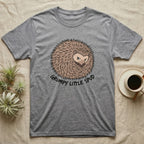 Grey t-shirt with a grumpy hedgehog design that says "Grumpy Little Spud".
