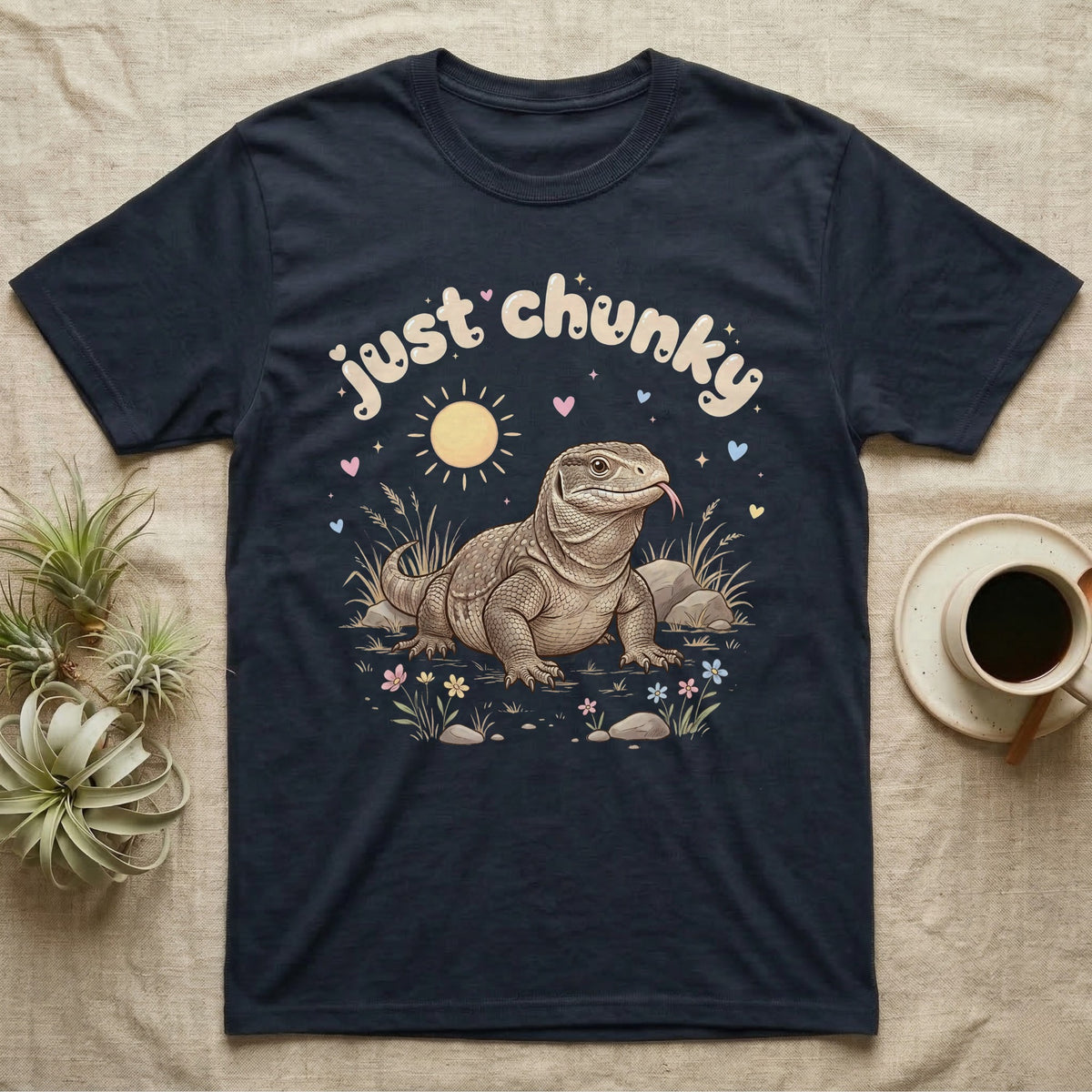 Savannah Monitor Softie T-Shirt in Navy — Plump savannah monitor lizard with flicking tongue under pastel bubble text "just chunky" and hearts.