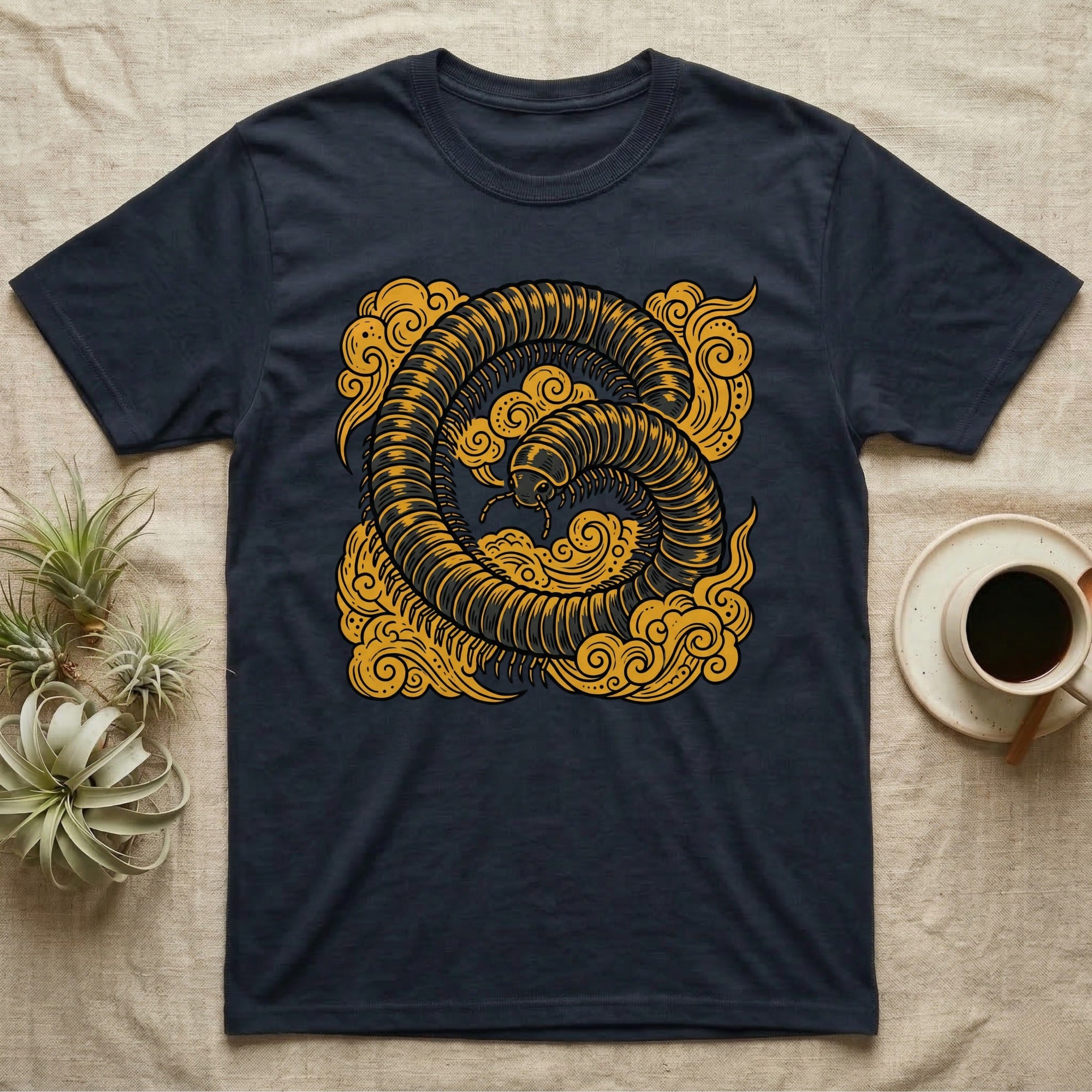 Dark t-shirt with a coiled yellow millipede design against a cloud background.