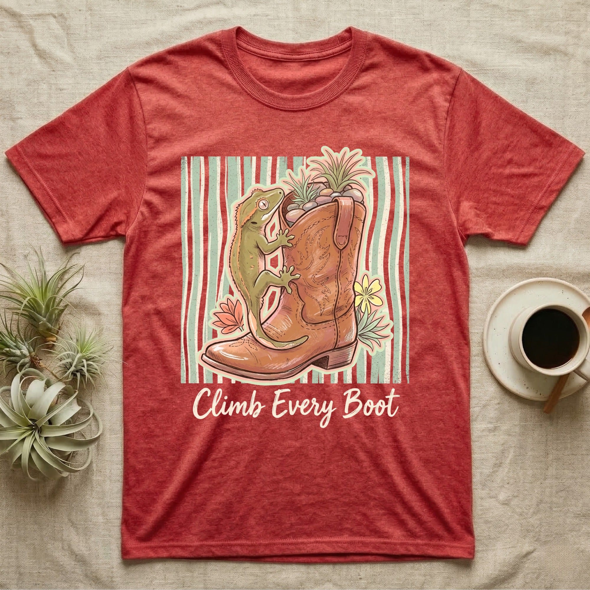 Red t-shirt with a cowboy boot, gecko, and flowers, text "Climb Every Boot".