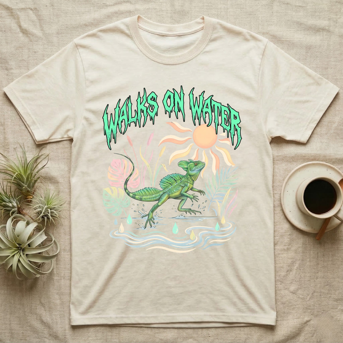Green Basilisk Feral T-Shirt in Natural — Green plumed basilisk sprinting across water below a dripping aqua-green metal "Walks On Water" wordmark
