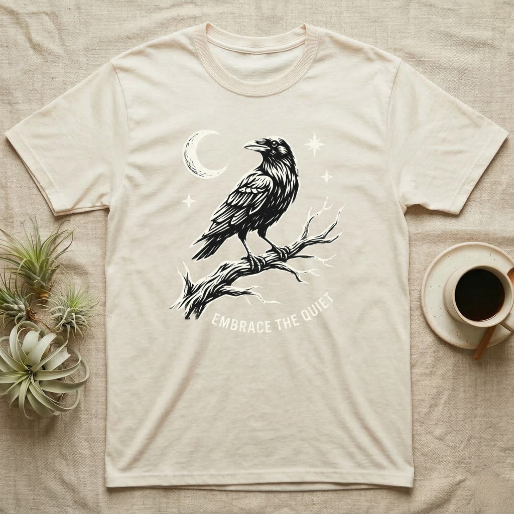 Cream t-shirt with raven illustration and "Embrace the Quiet" text.