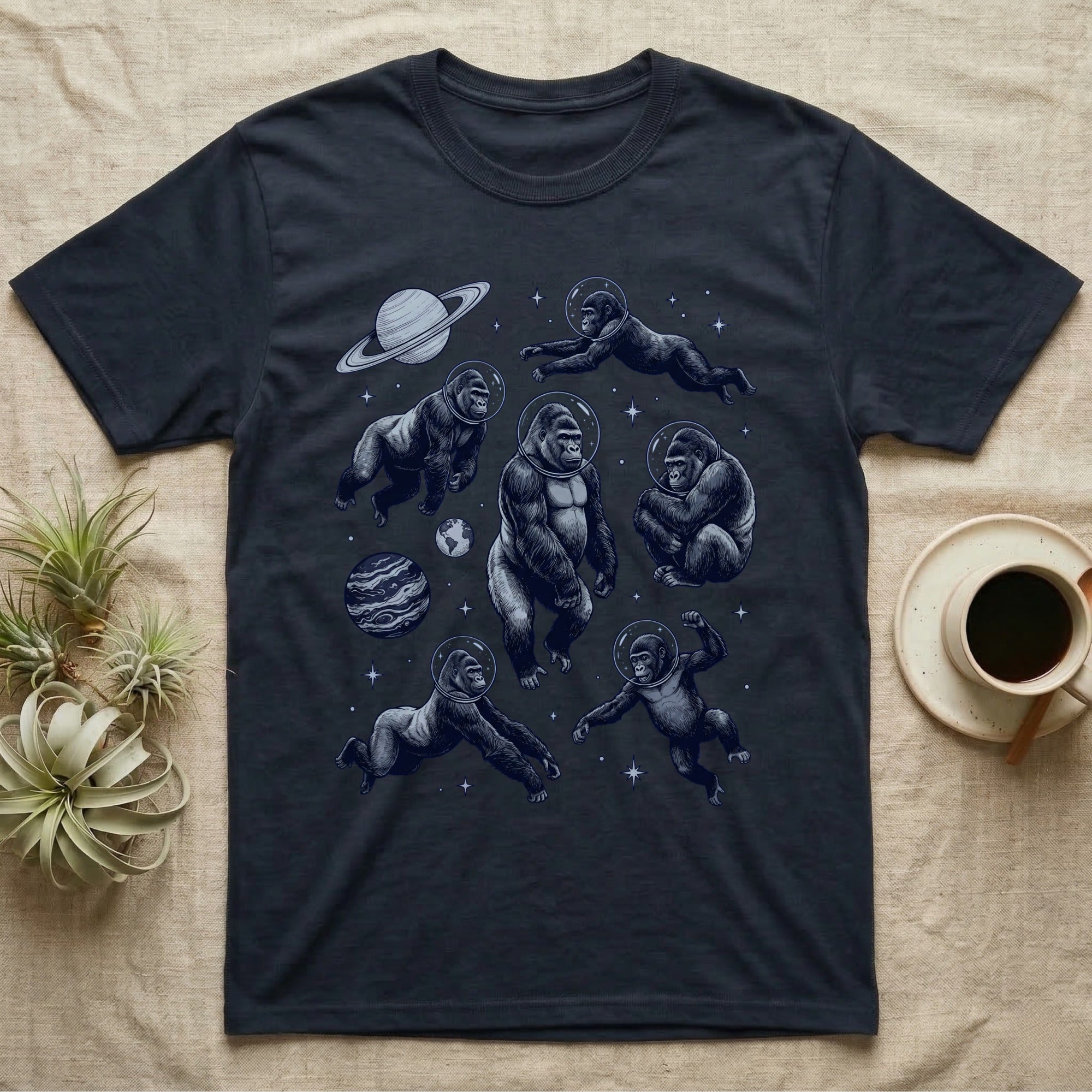 Gorillas in space float among planets and stars, on a dark t-shirt.