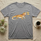 Bearded Dragon Blossom T-Shirt in Sport Grey — Watercolor illustration of an ochre bearded dragon holding a golden wattle blossom sprig, on a dark grey t-shirt.