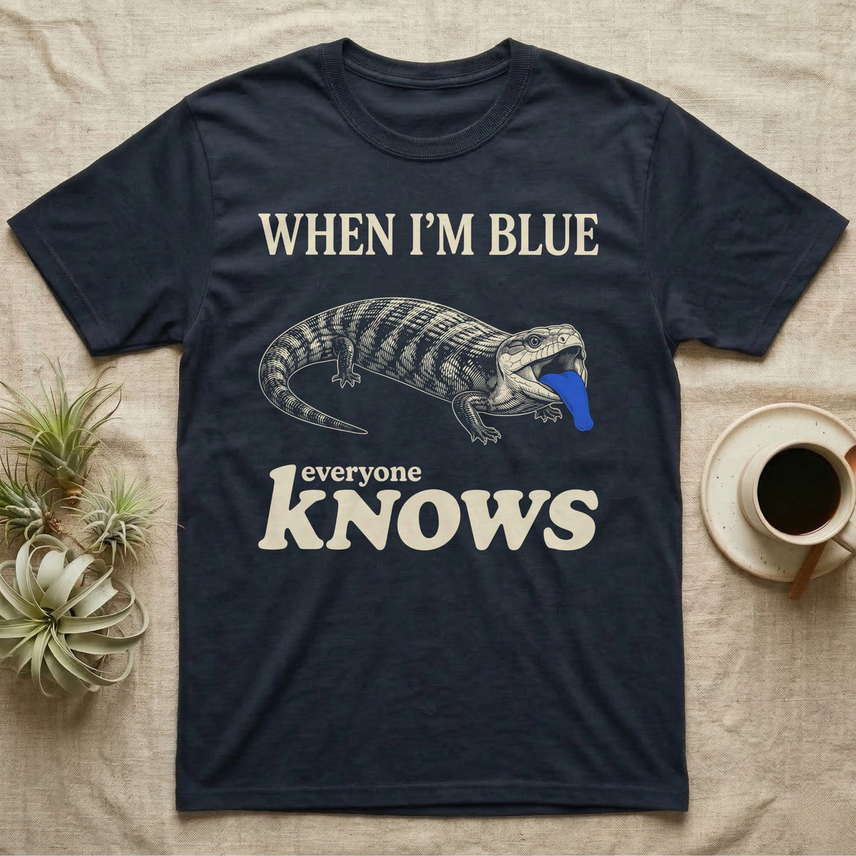 Blue-Tongue Skink Mood T-Shirt in Navy — Cream engraved blue-tongued skink on black flashing a cobalt blue tongue under the words WHEN I'M BLUE everyone KNOWS